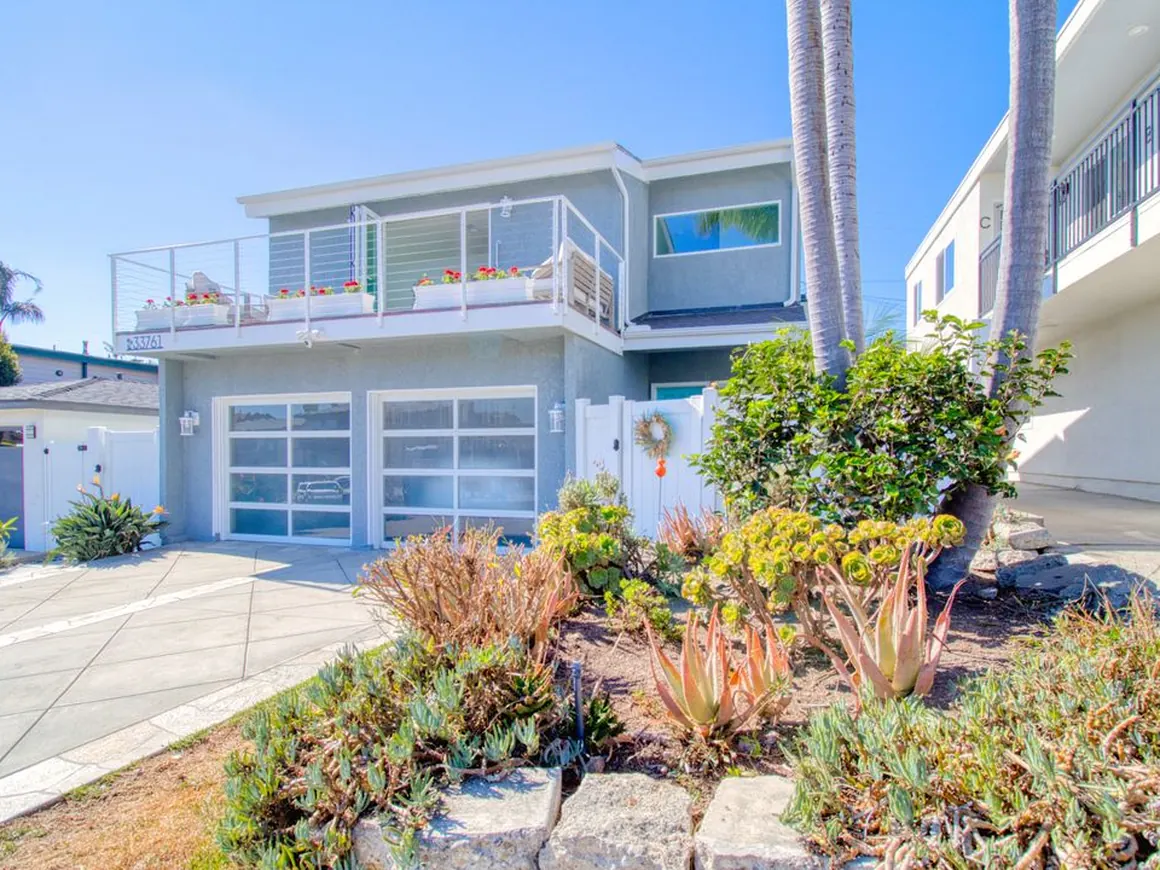 Coastal home exterior after renovation with drought-tolerant landscaping