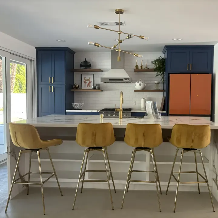 Remodeled kitchen with navy island and brass fixtures